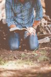 person reading book while kneeling