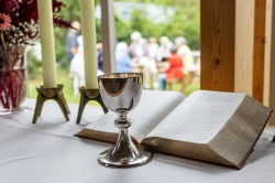 an open book and a pew cup on a table